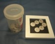 コインと、コインがちょうど入る穴の開けられた容器の教具のイメージ